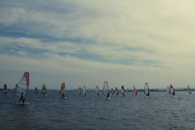 People in sea against sky