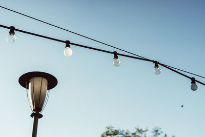 Low angle view of string light against clear sky