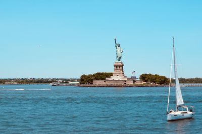 Statue of liberty in city against sky