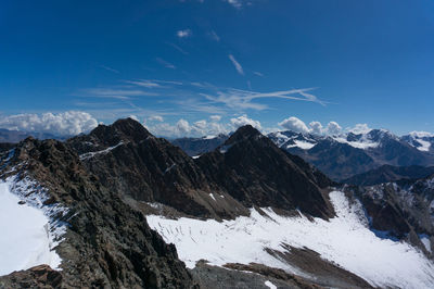 Scenic view of snowcapped mountains against blue sky