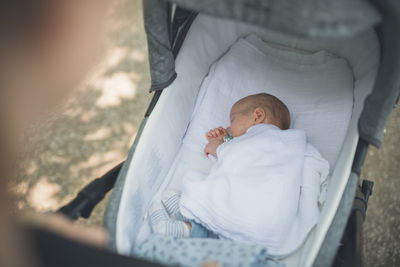 High angle view of cute baby boy sleeping on bed