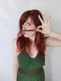 Portrait of beautiful young woman against white background