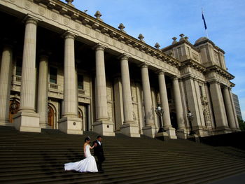 Low angle view of woman sitting on building