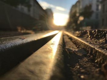 Close-up of railroad track against sky during sunset