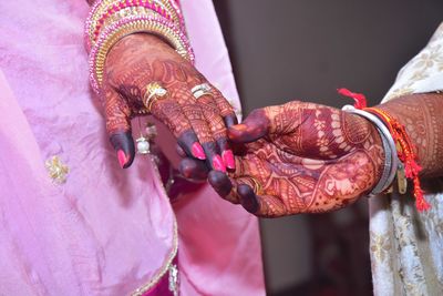 Midsection of couple holding rings in wedding ceremony