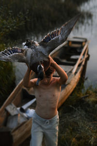 Man holding bird in water