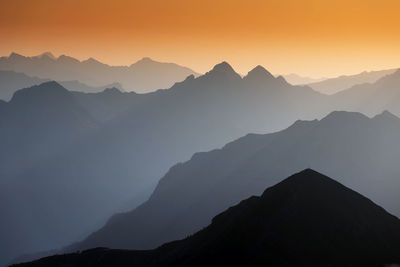 Scenic view of silhouette mountains against clear sky during sunset