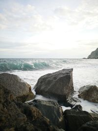 Scenic view of rocks on beach against sky