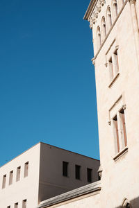 Low angle view of buildings against clear blue sky