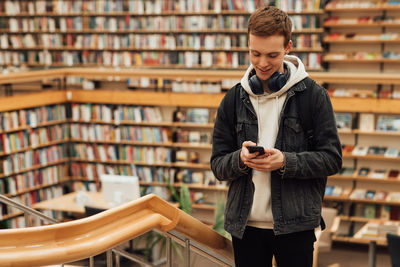 Portrait of young woman standing in library