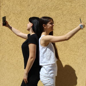 Young woman standing against wall