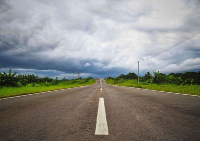 Road amidst field against sky
