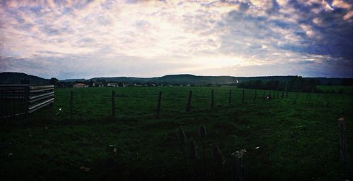 Scenic view of field against cloudy sky