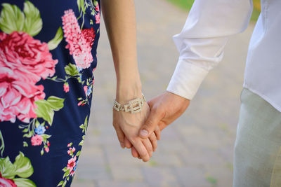 A man and a woman in love hold hands while walking outdoors. close-up of hands person