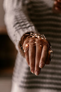 Midsection of woman with string light