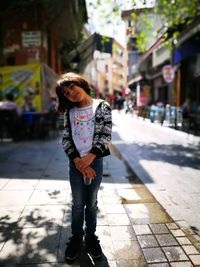 Portrait of girl standing on footpath