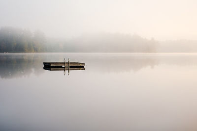 Scenic view of lake against sky during foggy weather