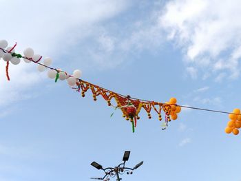 Low angle view of dahi handi decorations against sky