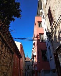 Low angle view of buildings against clear blue sky