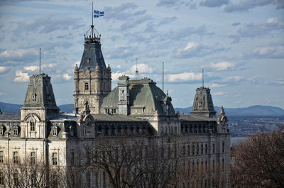 Buildings in city against cloudy sky