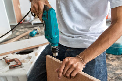 Midsection of man working on wood