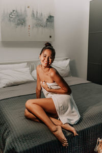 Young girl sitting in the bedroom on the bed