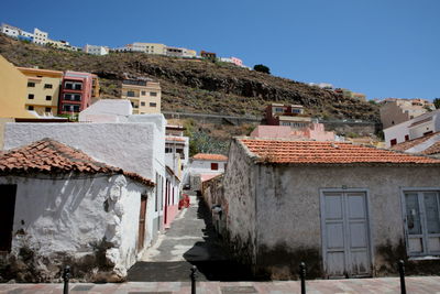 Houses by street in town against clear blue sky