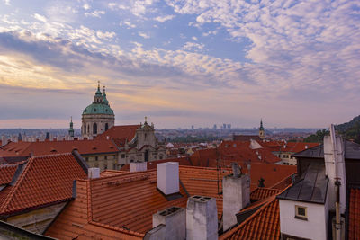 Buildings in city against cloudy sky