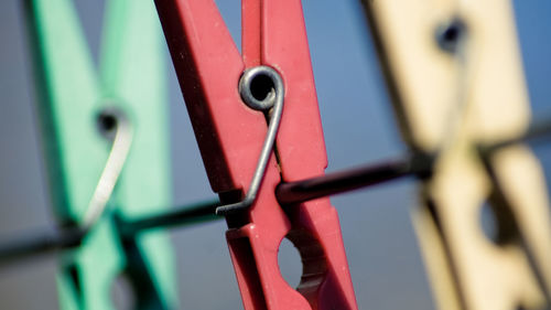 Close-up of clothespins attached to metal cable