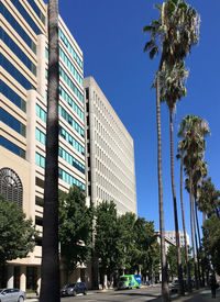 Low angle view of modern buildings against blue sky