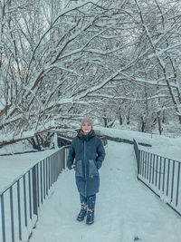 Full length of woman walking on snow covered field