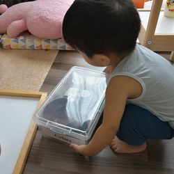 High angle view of boy holding plastic box at home