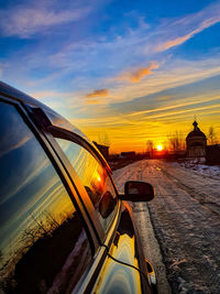 Car on road against sky during sunset