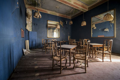 Empty chairs and tables in abandoned building