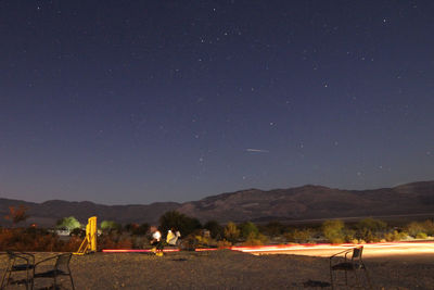 Scenic view of illuminated field against sky at night