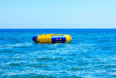 Boat floating on sea against clear sky