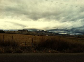 Country road against cloudy sky