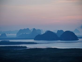 Scenic view of sea and mountains against sky during sunset