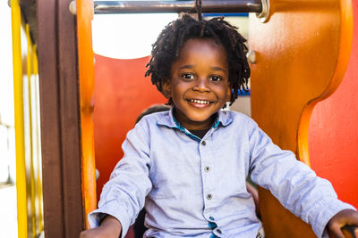 Portrait of smiling boy sitting outdoors