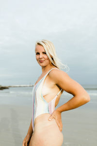 Portrait of smiling young woman standing at beach