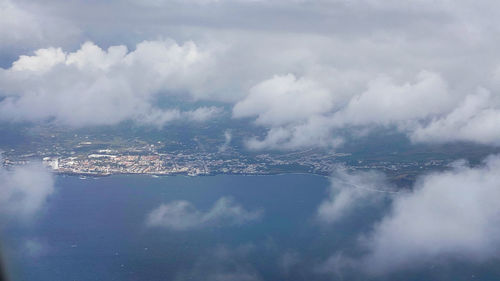 Aerial view of city by sea against sky