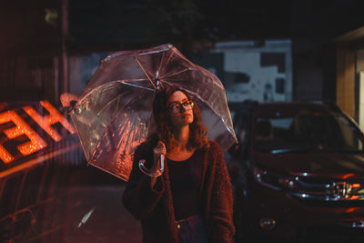 Woman looking at camera while standing in car