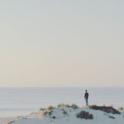 Man on beach against clear sky