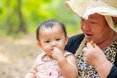 Portrait of grandmother carrying daughter