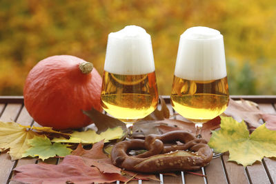 Close-up of beer in wineglasses by pretzel on table