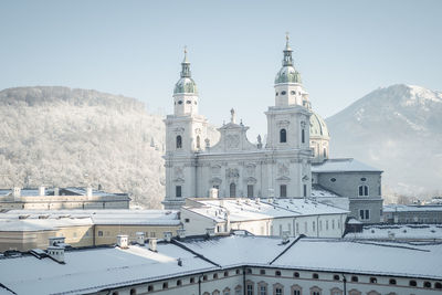 Salzburg cathedral and surrounding churches covered in snow on a sunny winter day