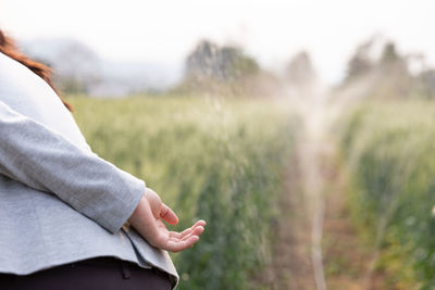 Midsection of woman hand on field