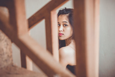 Portrait of beautiful young woman sitting on staircase