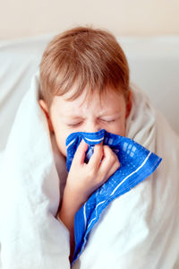 Sick child with thermometer. boy with a runny nose. 1boy blows his nose in a handkerchief