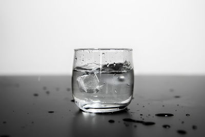 Close-up of wet glass against white background